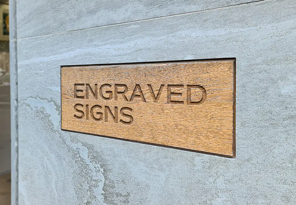 Engraved writing on wooden piece on a cement wall
