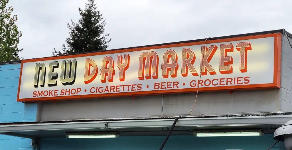 New Day Market Cabinet Sign on blue building