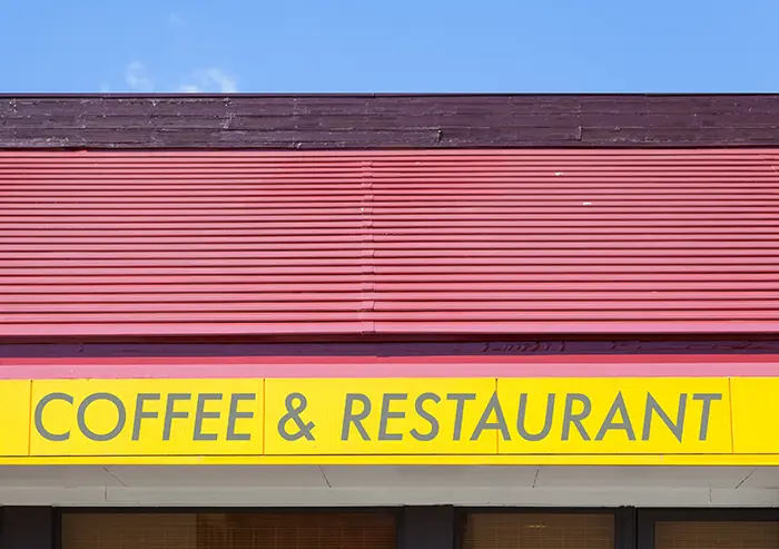 Coffee and restaurant parapet sign in yellow with reed roof