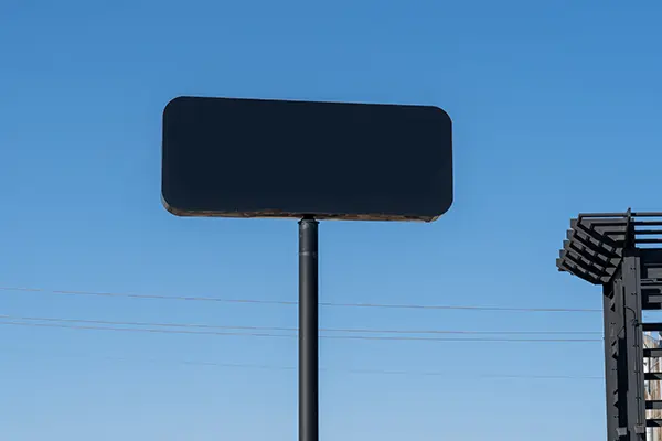 Black pole sign and edge of a building